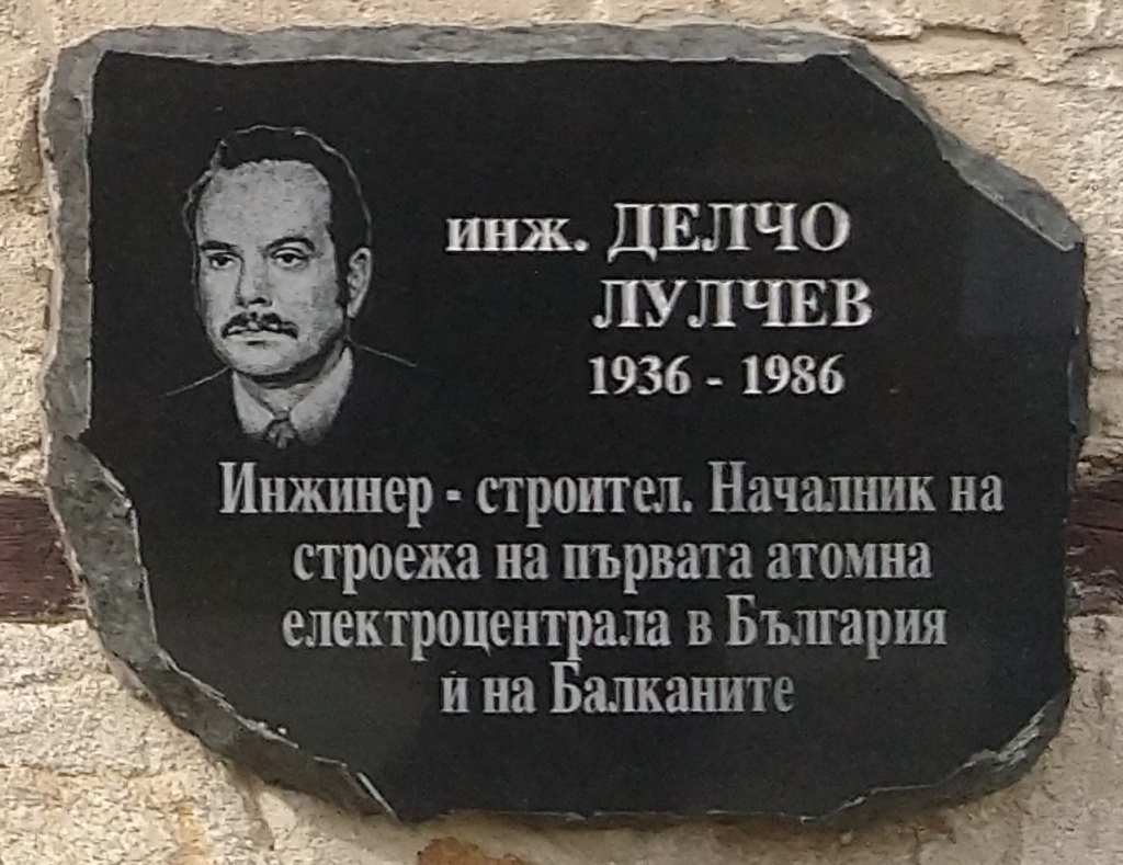 Черна паметна плоча с гравиран портрет на мъж с мустаци и надпис „инж. Делчо Лулчев 1936–1986, инженер-строител“.